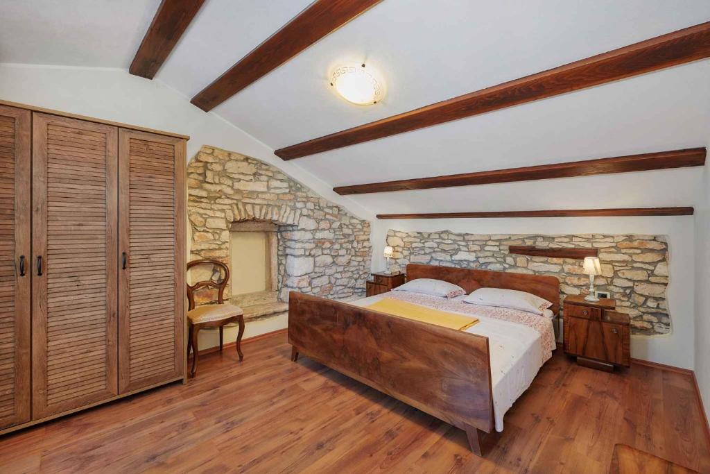 sypialnia z łóżkiem i kamienną ścianą w obiekcie Holiday home in Medulin/Istrien 9006 w Medulinie