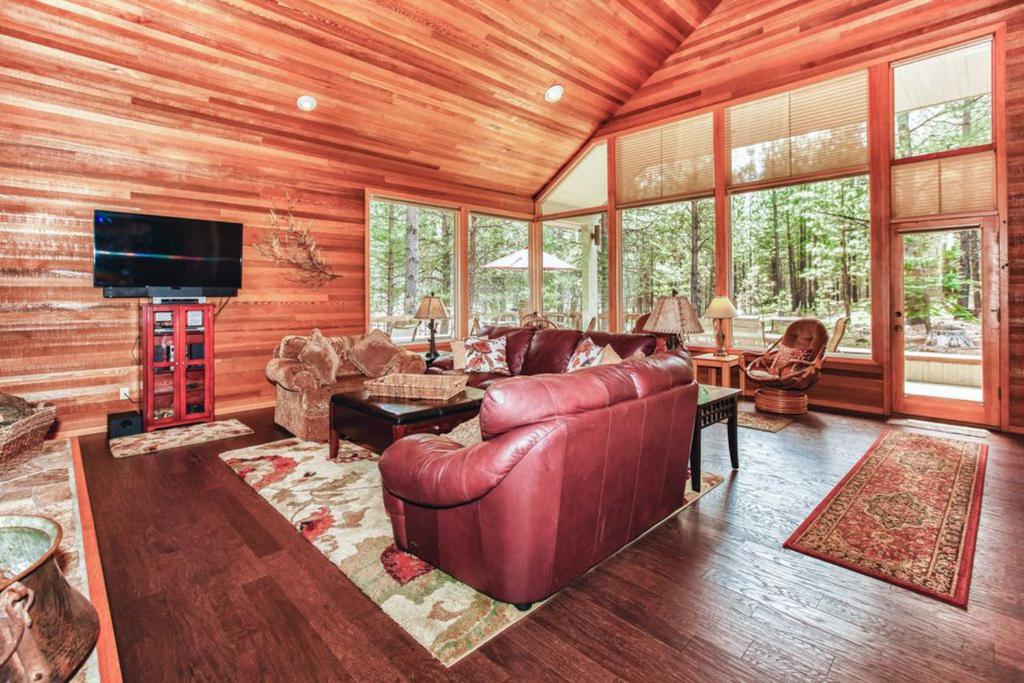 ein Wohnzimmer mit einem Ledersofa und einem TV in der Unterkunft Forest Escape - GM 428 in Black Butte Ranch