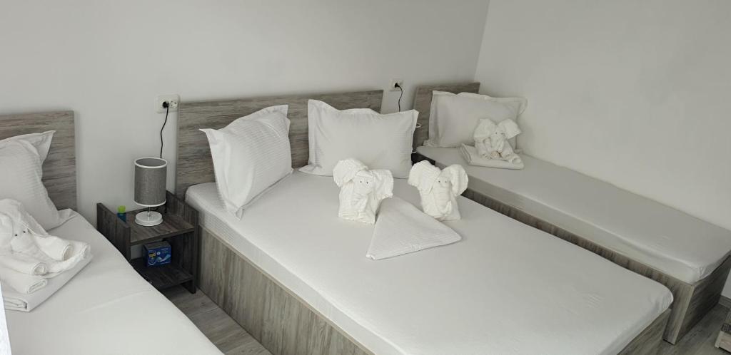 Una cama blanca con almohadas blancas y toallas. en Casa David, en Constanţa