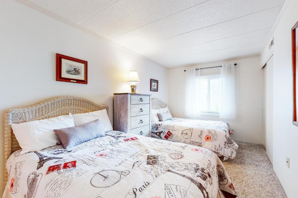 a bedroom with two beds and a window at Assateague House II in Ocean City
