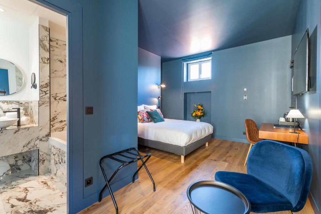 a bedroom with blue walls and a bed and a chair at Boutique Hotel Nice Côte d'azur in Nice