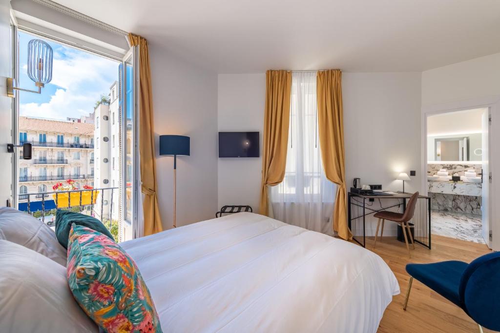 a bedroom with a bed and a large window at Boutique Hotel Nice Côte d'azur in Nice
