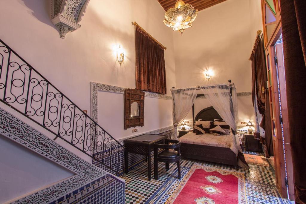 a bedroom with a bed and a staircase with a mirror at Riad Naila & suite in Fez