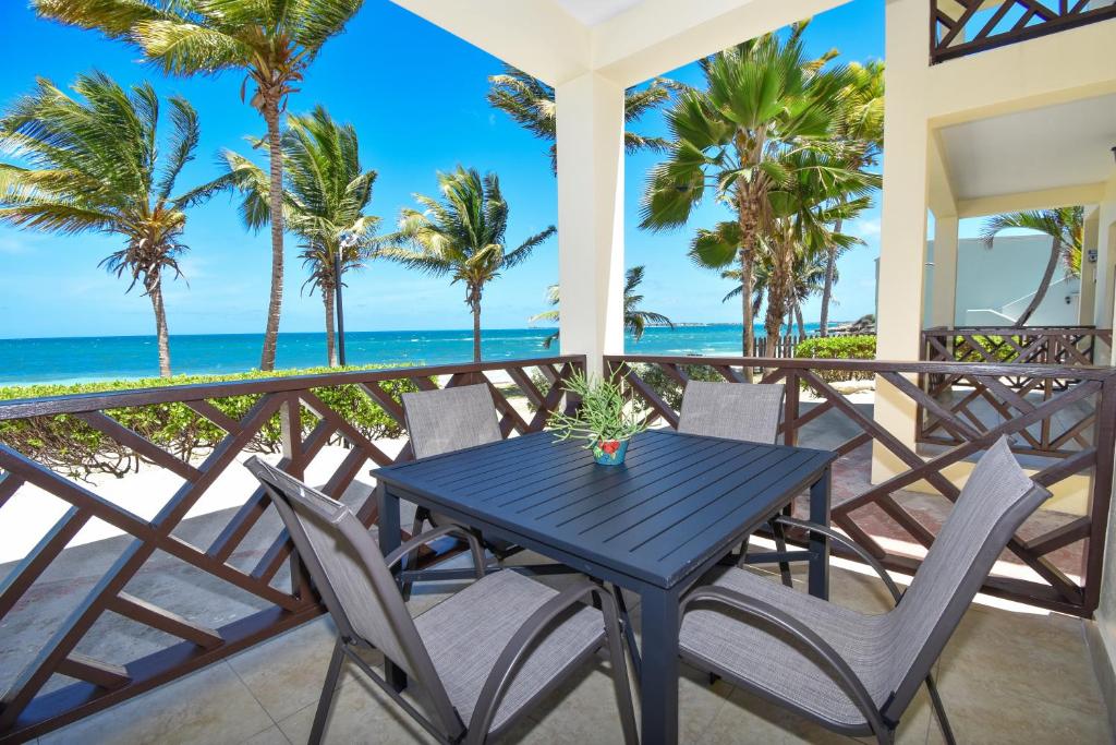 Una mesa y sillas azules en un balcón con la playa. en Lord Nelson Hotel &amp; Residences, en Barnes Hill