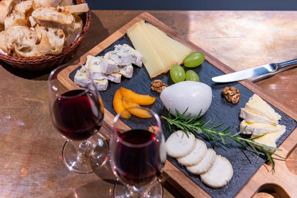 a cutting board with two glasses of wine and cheese at Boutique Hotel Nice Côte d'azur in Nice