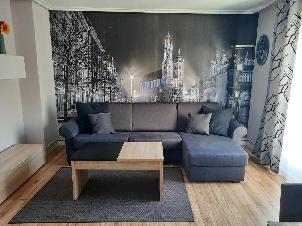 salon z niebieską kanapą i malowidłem ściennym w obiekcie estudio centro w mieście Logroño