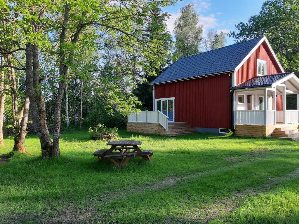 a picnic table in front of a red barn at Charming holiday home Villa Berika in Ekshärad