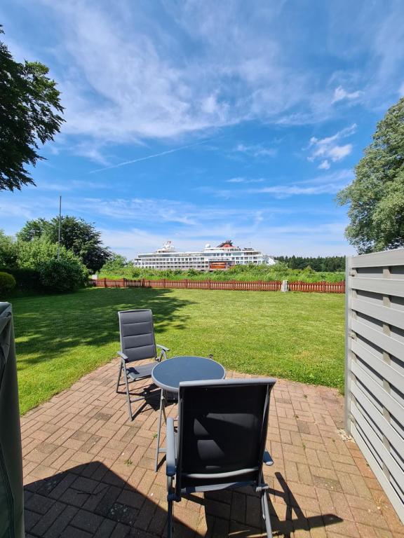 a patio with a table and chairs and a building at Ferienwohnung am Nord-Ostsee-Kanal in Breiholz