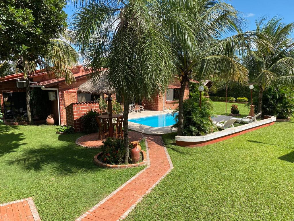 een huis met een zwembad in een tuin bij Casa por Temporadas in Santa Cruz de la Sierra