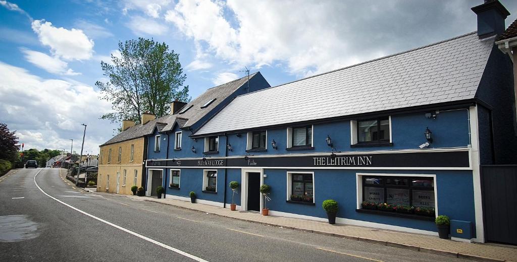 un edificio azul al lado de una calle en The Leitrim Inn and Blueway Lodge, en Leitrim