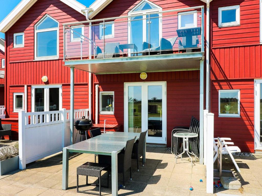 6 person holiday home in Hadsund في Hadsund: منزل أمامه طاولة وكراسي