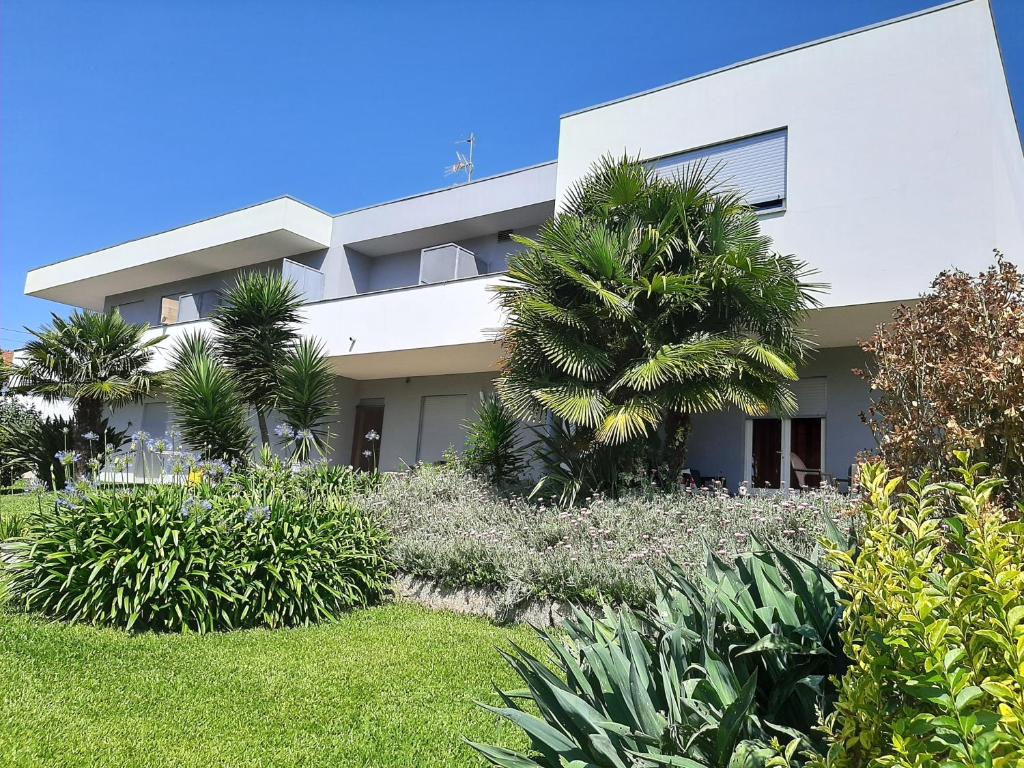 un gran edificio blanco con palmeras delante en Quinta de Reiriz en Monção