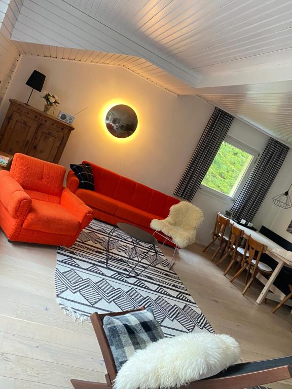 a living room with an orange couch and a table at Bergwaldstudio Moderne Ferienwohnung in Wiedweg