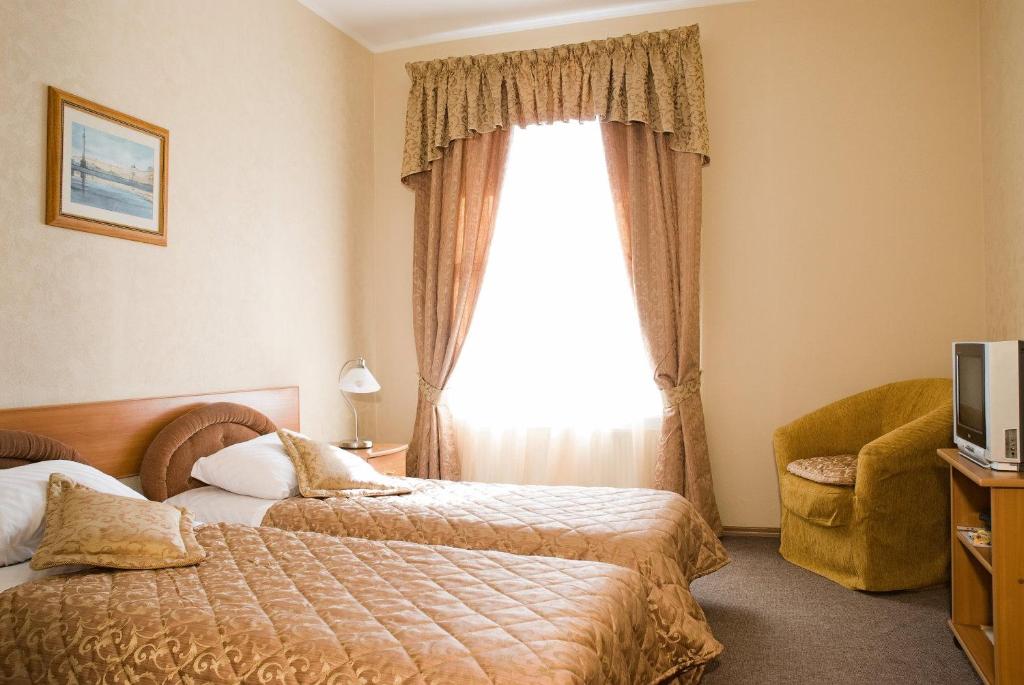 a hotel room with two beds and a window at Nevsky Guest House in Saint Petersburg