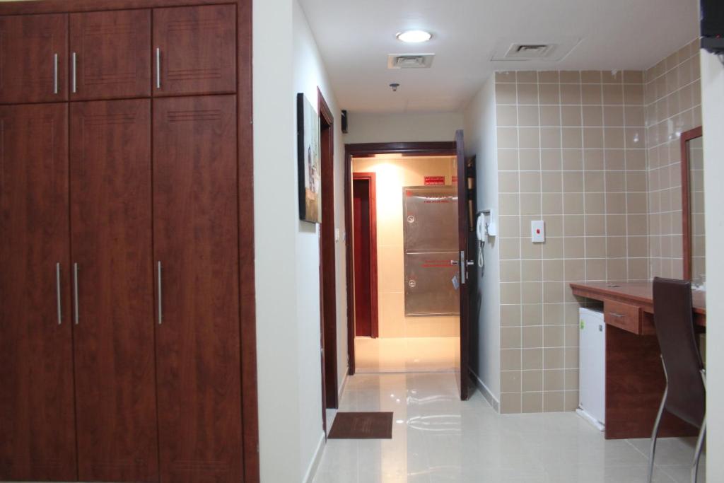 a kitchen with wooden cabinets and a hallway to a bathroom at Africana Hotel in Dubai