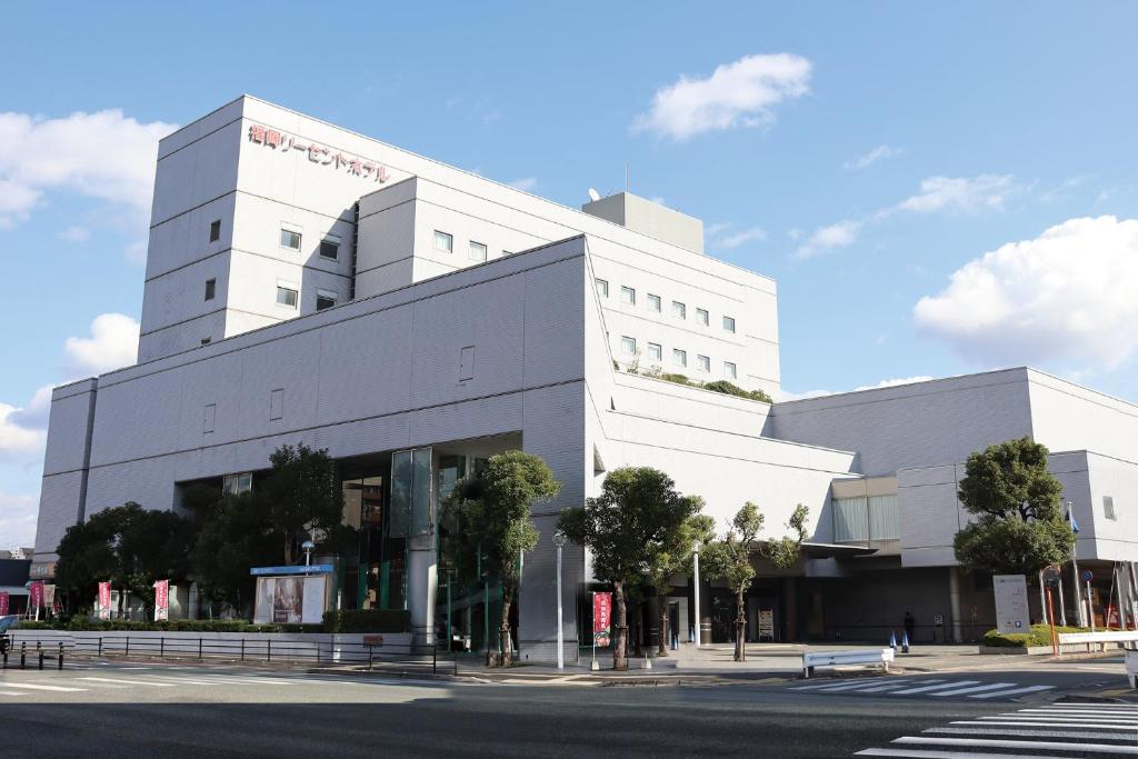 a large white building on a city street at Fukuoka Recent Hotel in Fukuoka