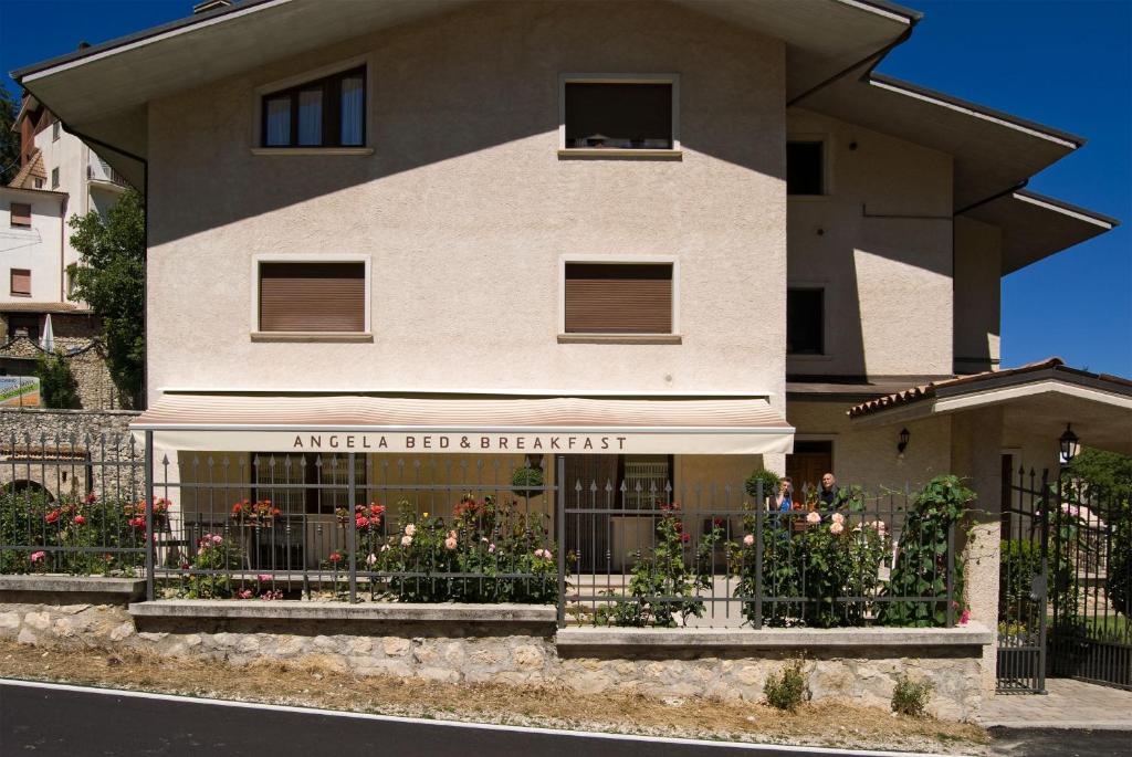 a house with a flower garden in front of it at B&B Angela in Scanno