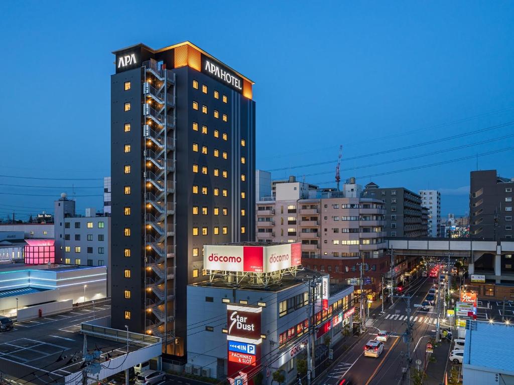 APA Hotel Nishifunabashi Ekimae في Nakayama: مبنى طويل على شارع المدينة مع حركة المرور