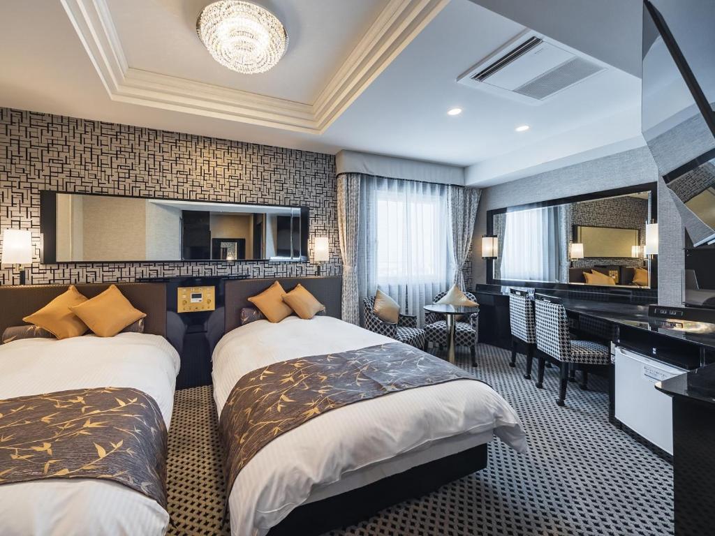 a hotel room with two beds and a mirror at APA Hotel Nishifunabashi Ekimae in Funabashi