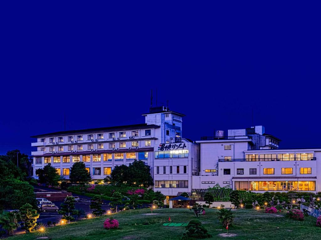 a large white building at night with lights at Yukai Resort Premium Shima Saichoraku in Shima