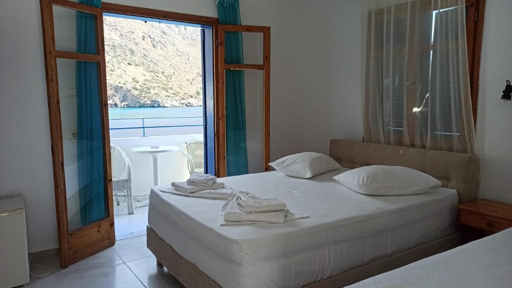 a bedroom with a bed and a large window at Sifis in Loutro