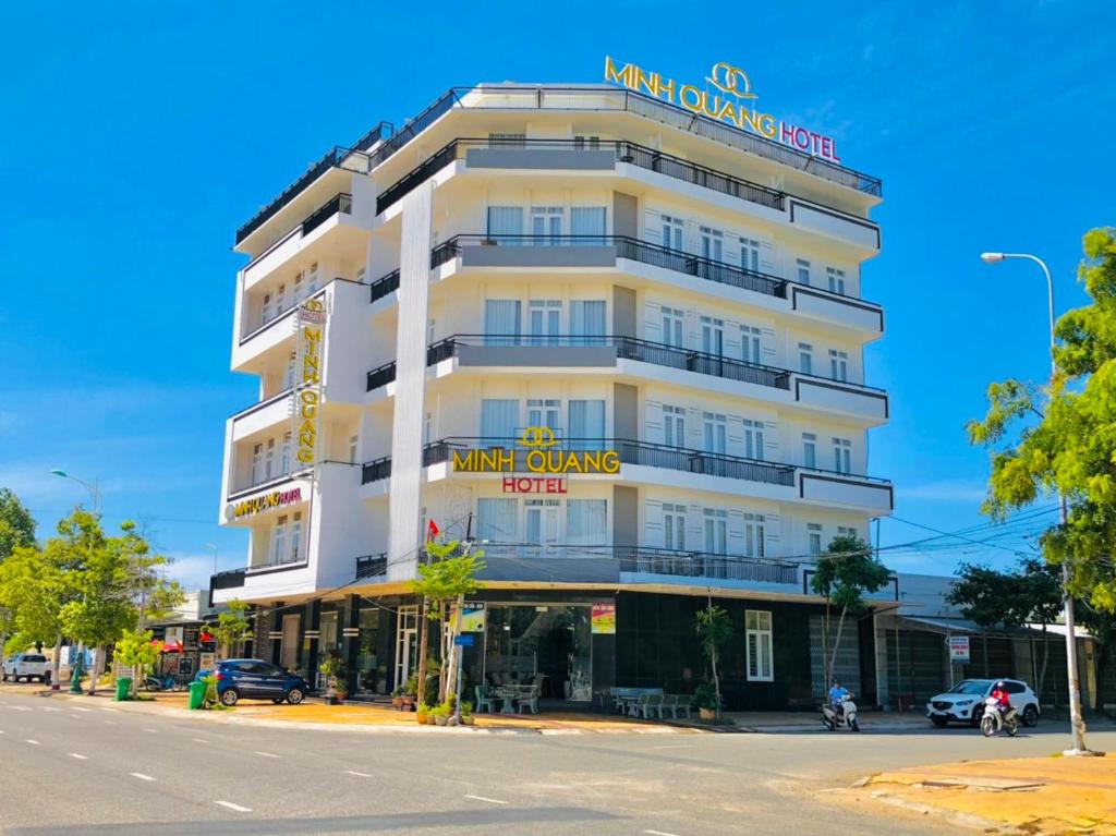 a white building with a sign on it on a street at Khách sạn Minh Quang in Phan Rang