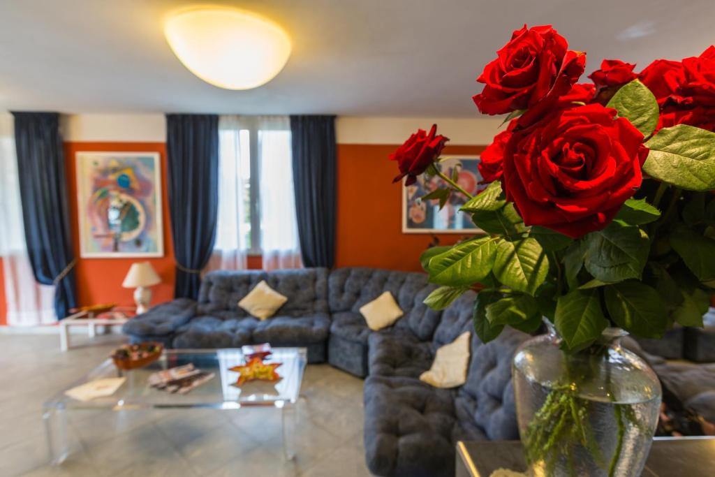 a living room with a vase with red roses in it at Hotel Turandot in Torre del Lago Puccini