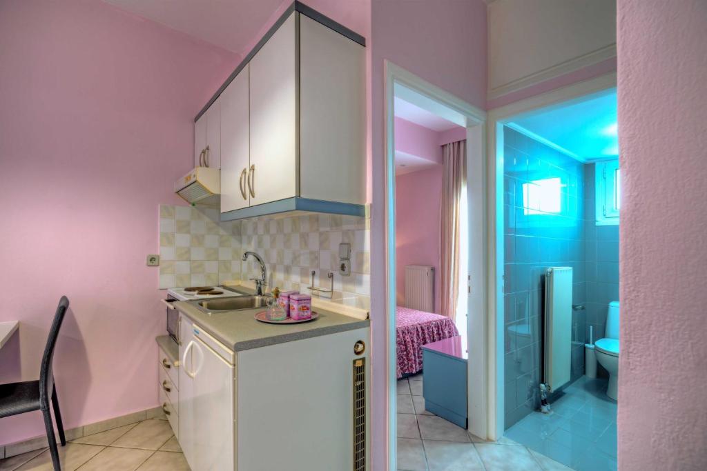 - une cuisine avec des murs roses et bleus et un évier dans l'établissement cozy apartment-1, à Ayía Marína