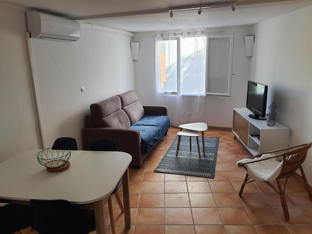 un salon avec un canapé et une table dans l'établissement Appartement avec parking privatif à Collioure, à Collioure