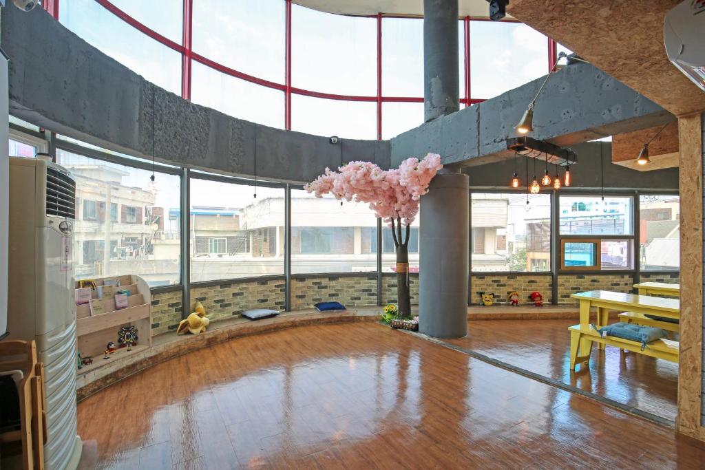 a large room with a wooden floor and large windows at Dashim Guest House in Gunsan-si