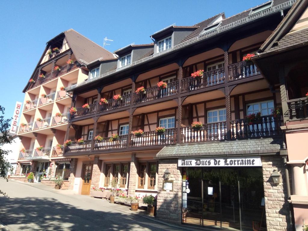 Hotel Munsch Restaurant & Wellness, Colmar Nord - Haut-Koenigsbourg في سانت هيبوليت: مبنى كبير عليه شرفات وزهور