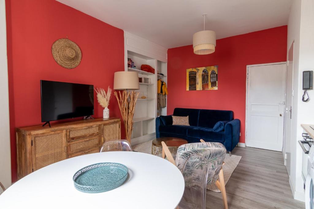 een woonkamer met rode muren en een witte tafel bij DUPLEX LE SAINT JEAN in Saumur