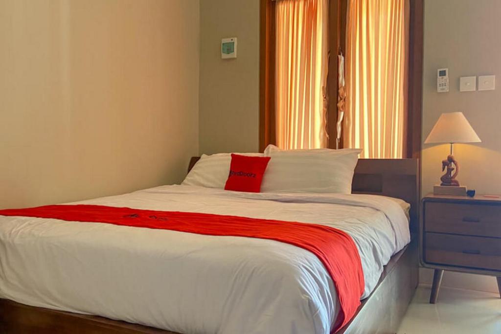 sypialnia z dużym łóżkiem i czerwonym kocem w obiekcie RedDoorz near Mertasari Beach 2 w mieście Pesanggaran