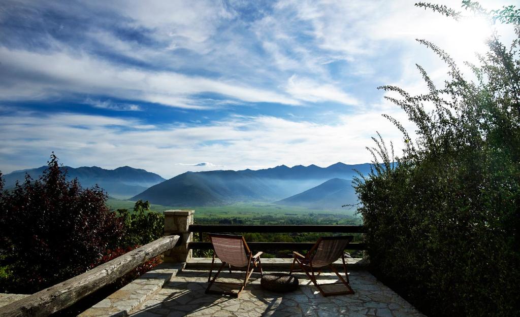 2 sillas sentadas en un patio con vistas a las montañas en Villa Vager, en Levidhion