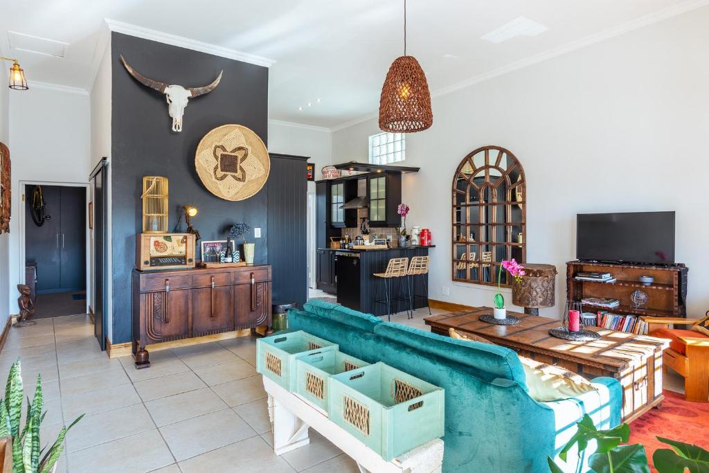 uma sala de estar com um sofá azul e uma mesa em Spacious Gem, Outdoor Space, Close to TBMTN&City em Cidade do Cabo