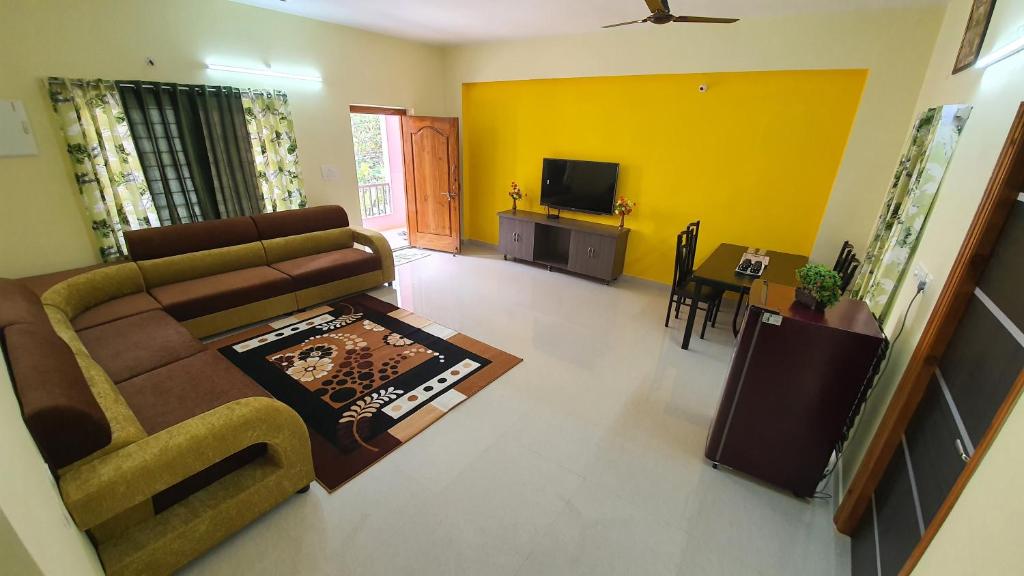 a living room with a couch and a tv at Tirupati Homestay - 2BHK AC Family Apartments near Alipiri and Kapilatheertham - Walk to A2B Veg Restaurant - Super fast WiFi - Android TV - 250 Jio Channels - Easy access to Tirumala in Tirupati