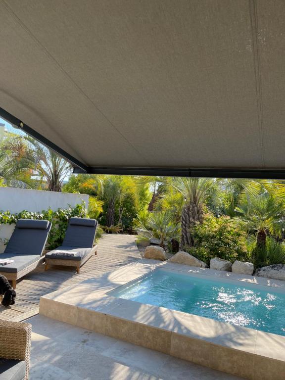 a swimming pool in a backyard with two lounge chairs at Casa Di l'Ortu in Ajaccio