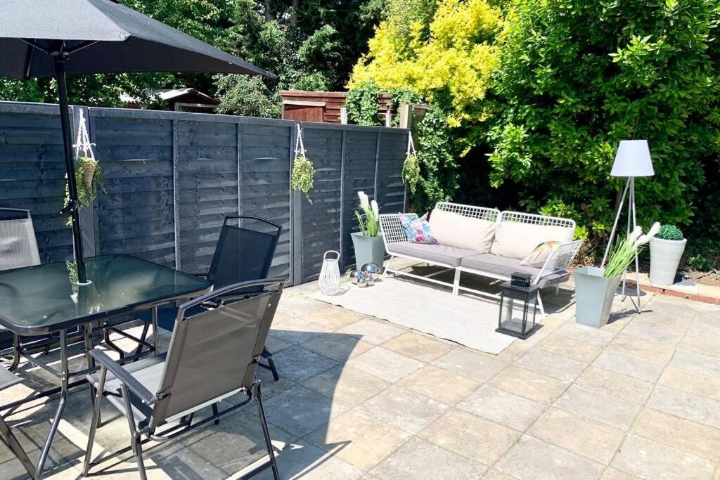 a patio with a table and chairs and an umbrella at Contemporary 3 bed house with spacious garden close to Stratford in London