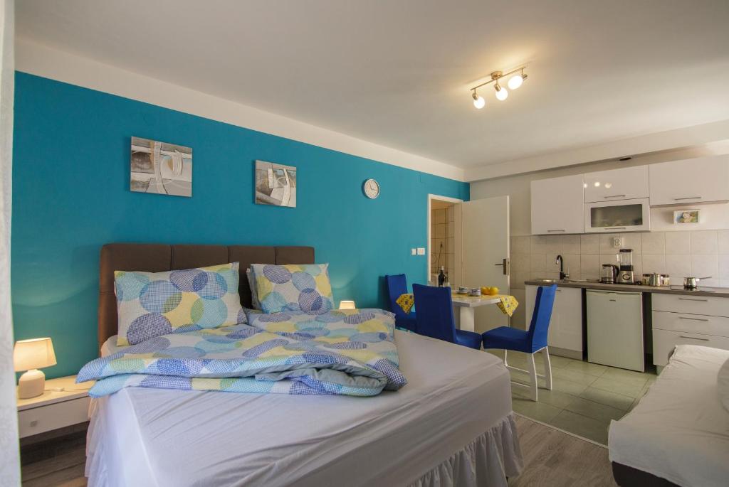 a bedroom with a bed and a blue wall at Apartment Filomena in the center in Komiža