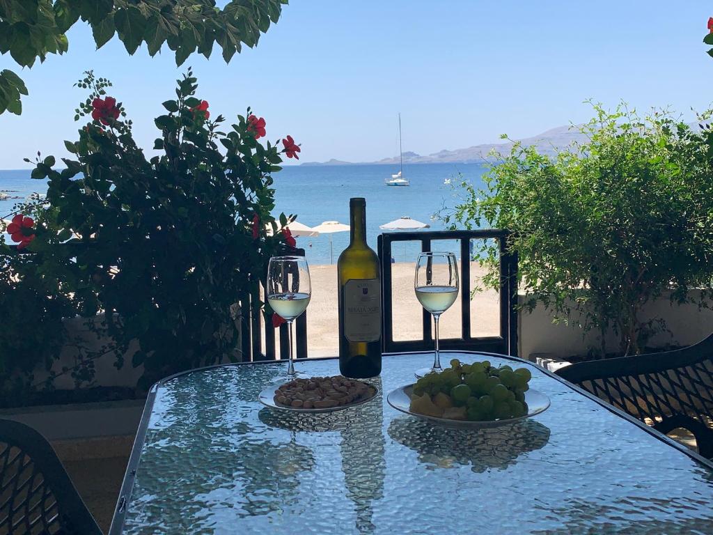ハラキにあるHaraki Beach Houseのワイン1本とフルーツプレートを用意したテーブル