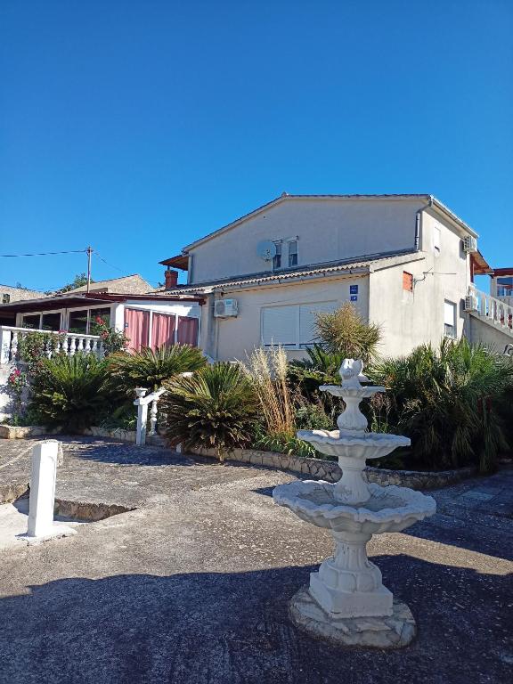 a stone fountain in front of a house at Apartments Ruža Dragove Dugi otok in Dragove