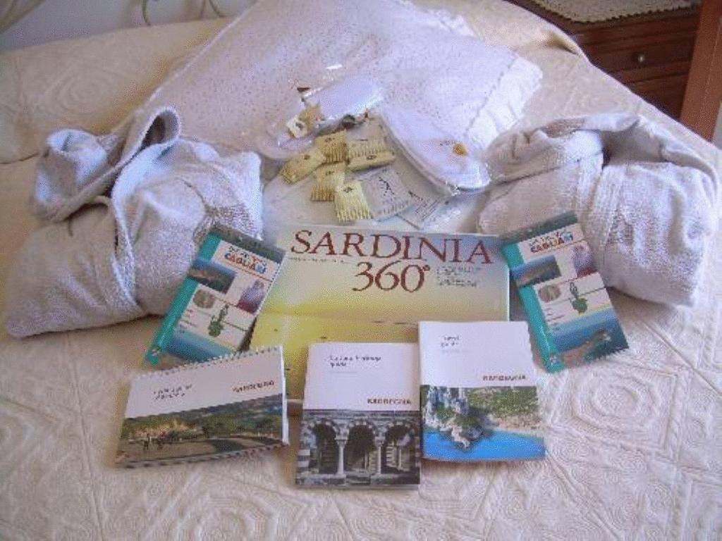 un libro sentado en la parte superior de una cama con libros en Ariedo Bed And Breakfast en Capoterra