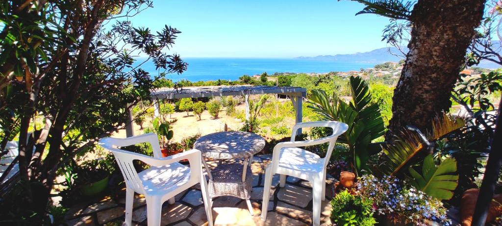 una mesa y sillas en la parte superior de un jardín en La Dolce Vista, en Magomadas