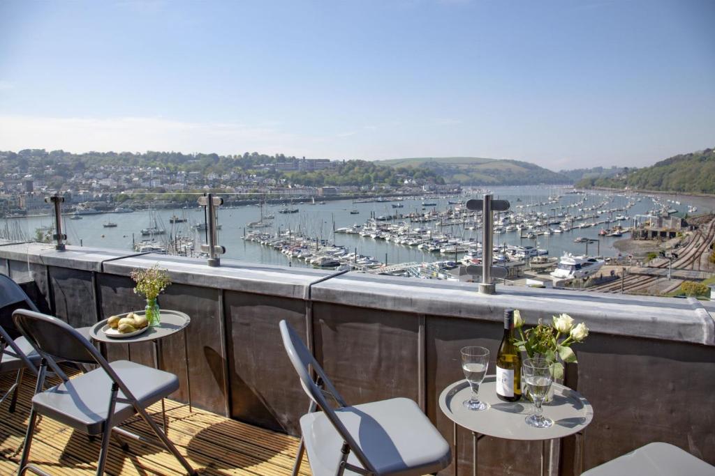 a balcony with two tables and chairs and a harbor at Waterview House, Kingswear in Kingswear