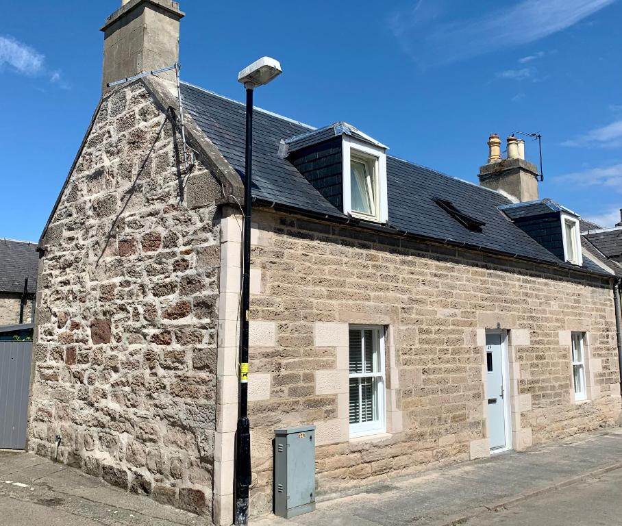 a brick building with a street light next to it at Rileys Cottage Nairn in Nairn