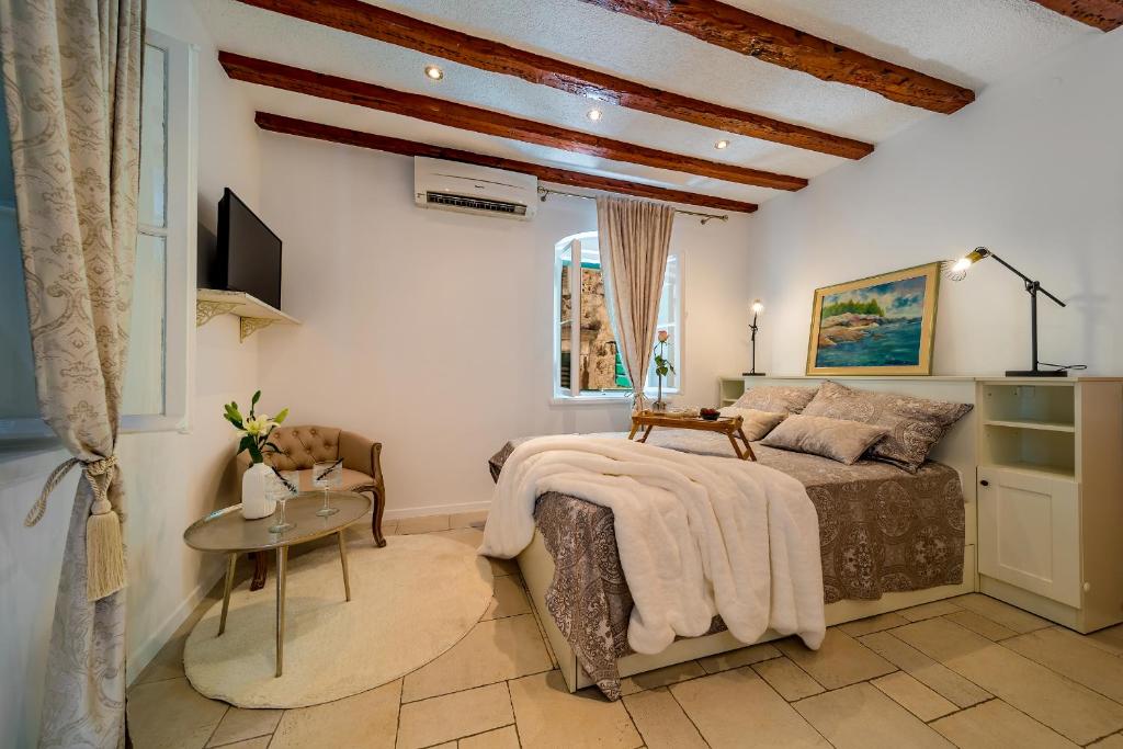 1 dormitorio con cama, mesa y TV en Charming Old Town Apartment Pjaca Split, en Split