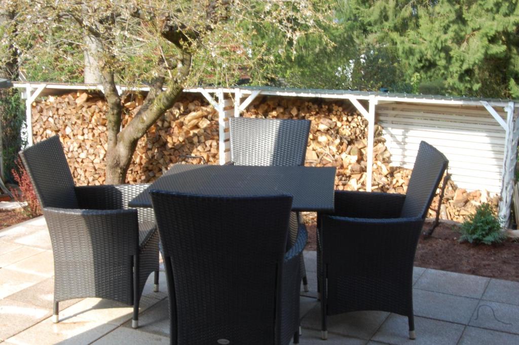 - une table et des chaises noires sur la terrasse dans l'établissement Wohnung mit Kamin Terrasse und Grill in der Nähe von Nürnberg, à Burgthann