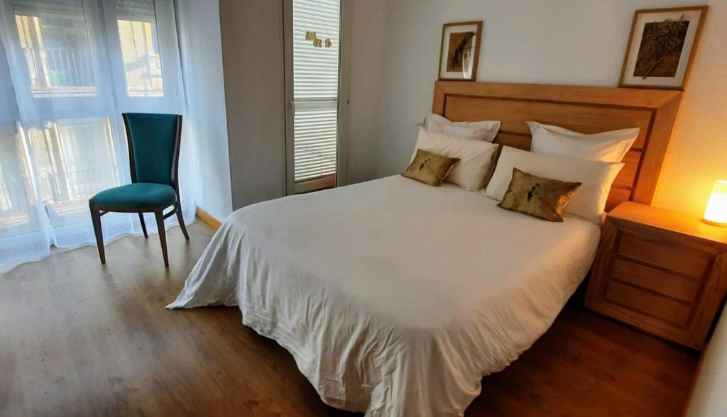 1 dormitorio con 1 cama blanca y 1 silla en Apartamento en Reina Victoria en Santander