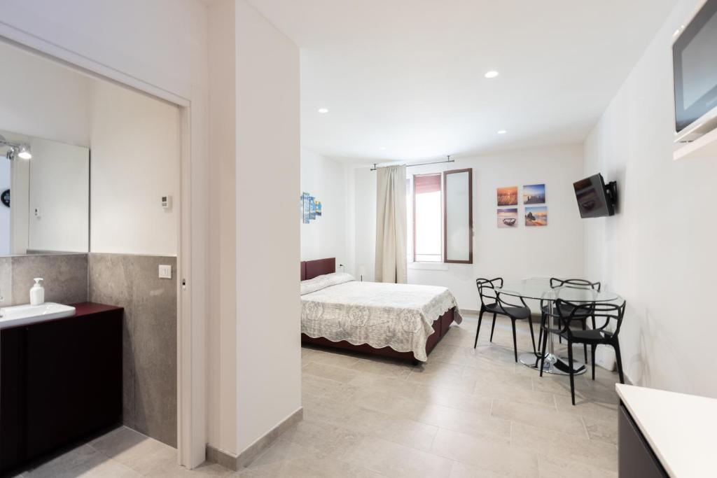 1 dormitorio con 1 cama, mesa y sillas en Goito 4, Bologna by Short Holidays, en Bolonia