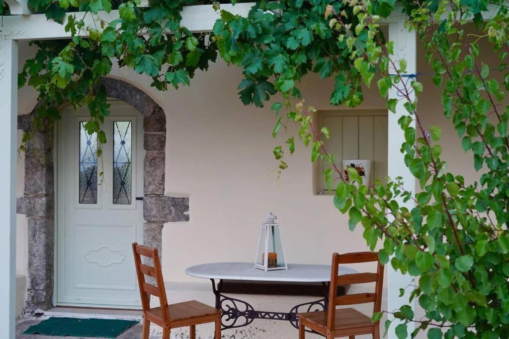 a table and two chairs in front of a door at Elia Houses - Traditional House With Backyard in Kastrisiánika